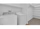 Convenient laundry room equipped with washer, dryer, shelving, and wood-look flooring at 9024 Hazy Haven Ct, Las Vegas, NV 89149