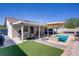 Charming backyard with a small pool, covered patio, dining set, and low-maintenance turf at 925 Mandolin Way, North Las Vegas, NV 89032