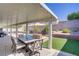 Cozy backyard patio with a dining set, covered area, view of the pool and neatly manicured greenery at 925 Mandolin Way, North Las Vegas, NV 89032