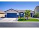 Charming single-story home with blue garage door, palm tree, and artificial turf lawn at 925 Mandolin Way, North Las Vegas, NV 89032