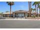 Community clubhouse with tile roof, lush landscaping, and ample parking at 9270 Apache Springs Dr, Las Vegas, NV 89117