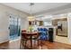 Bright dining area featuring hardwood floors, a modern light fixture, and access to the kitchen and backyard at 9270 Apache Springs Dr, Las Vegas, NV 89117