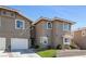 Inviting exterior view of a townhome showcases a two-car garage, neat landscaping, and classic architectural details at 9270 Apache Springs Dr, Las Vegas, NV 89117