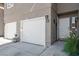 Welcoming entrance to a townhome features a two-car garage and a nicely landscaped walkway to the front door at 9270 Apache Springs Dr, Las Vegas, NV 89117
