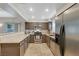 Galley kitchen features granite countertops, stainless steel appliances, and sleek brown cabinets at 9270 Apache Springs Dr, Las Vegas, NV 89117
