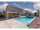 Backyard with a refreshing pool, covered patio, and drought-tolerant landscaping at 9709 Casper Peak Ct, Las Vegas, NV 89117