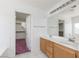 Bright bathroom with dual sinks, wood cabinets, and a walk-in closet with carpet at 9709 Casper Peak Ct, Las Vegas, NV 89117