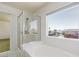Bathroom featuring a glass-enclosed shower, soaking tub, and window views at 9709 Casper Peak Ct, Las Vegas, NV 89117