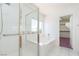 Bright bathroom with a glass-enclosed shower, tub, and a walk-in closet at 9709 Casper Peak Ct, Las Vegas, NV 89117