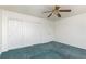 Bedroom features green carpet, a ceiling fan, and closet space at 9709 Casper Peak Ct, Las Vegas, NV 89117