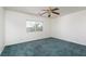 Bedroom features green carpet, a ceiling fan, and a window offering a view of the yard at 9709 Casper Peak Ct, Las Vegas, NV 89117