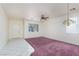 Bright living room with neutral walls, ceiling fan, and tile/carpet flooring at 9709 Casper Peak Ct, Las Vegas, NV 89117