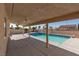 Relaxing backyard with a pool, covered patio with ceiling fans, and desert landscaping at 9709 Casper Peak Ct, Las Vegas, NV 89117