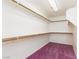 Large walk-in closet with wood shelving and purple carpeting at 9709 Casper Peak Ct, Las Vegas, NV 89117