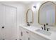 Modern bathroom with double sinks, white cabinets, quartz counters, and gold-framed mirrors at 1006 Blue Lantern Dr, Henderson, NV 89015