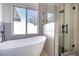 Modern bathroom featuring a standalone tub, natural light, and a glass-enclosed shower at 1006 Blue Lantern Dr, Henderson, NV 89015