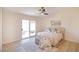 Cozy bedroom featuring a ceiling fan and sliding glass doors to the backyard at 1006 Blue Lantern Dr, Henderson, NV 89015
