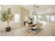 Elegant dining room featuring a fireplace, a modern light fixture, and large windows that let in plenty of natural light at 1006 Blue Lantern Dr, Henderson, NV 89015