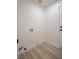 A simple laundry room with connections and wood look flooring at 1006 Blue Lantern Dr, Henderson, NV 89015