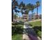 Charming condo complex featuring lush landscaping, palm trees, and blue awnings over the windows on a sunny day at 101 Luna Way # 104, Las Vegas, NV 89145