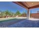 Covered patio offers views of the backyard's desert rock landscaping and grass at 10342 Kesington Dr, Las Vegas, NV 89135