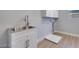 Functional laundry room with utility sink and overhead storage at 10342 Kesington Dr, Las Vegas, NV 89135