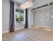 Elegant living room with a contemporary chandelier, large window, and light wood floors at 10342 Kesington Dr, Las Vegas, NV 89135