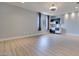 Open concept living area features a modern wet bar with stainless steel appliances, sleek cabinetry, and vinyl floors at 10342 Kesington Dr, Las Vegas, NV 89135