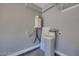 Neutral utility room with water softener and water heater with gray walls and white trim at 10342 Kesington Dr, Las Vegas, NV 89135