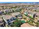 An elevated shot shows a community with many neutral-tone houses with a community pool at 11844 Mino Rio Ave, Las Vegas, NV 89138