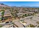 Aerial view showing a neighborhood full of homes with neutral exteriors in a desert landscape with mountains at 11844 Mino Rio Ave, Las Vegas, NV 89138