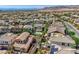 High-angle shot showing many houses with neutral roofs and a community surrounded by a mountain range at 11844 Mino Rio Ave, Las Vegas, NV 89138