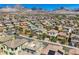 An elevated view shows a community of closely-packed houses in earthy tones with mountain views at 11844 Mino Rio Ave, Las Vegas, NV 89138