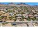 Community aerial view shows charming houses with neutral tones and desert landscaping against a mountain backdrop at 11844 Mino Rio Ave, Las Vegas, NV 89138