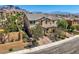 Two-story home with desert landscaping, a brick driveway, and mountain views behind the property at 11844 Mino Rio Ave, Las Vegas, NV 89138