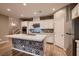 Stylish kitchen featuring a large island, white cabinetry, stainless appliances, and modern backsplash at 11844 Mino Rio Ave, Las Vegas, NV 89138