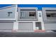 Modern townhome facade shows gray garage doors and neutral color scheme, enhanced curb appeal at 139 Aqua Commons Ln, Henderson, NV 89015