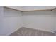 Empty walk-in closet offering ample storage space with hanging rods and neutral carpet at 139 Aqua Commons Ln, Henderson, NV 89015