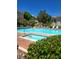 A luxurious pool is surrounded by lounge chairs, mature trees, and a building at 1500 Cardinal Peak Ln # 201, Las Vegas, NV 89144