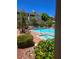A luxurious pool is surrounded by lounge chairs, mature trees, and a building at 1500 Cardinal Peak Ln # 201, Las Vegas, NV 89144