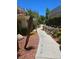A concrete walkway is surrounded by mature trees and stone landscaping at 1500 Cardinal Peak Ln # 201, Las Vegas, NV 89144