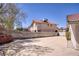 Large backyard featuring a concrete patio and block fencing in a desert landscape at 1590 Desertaire Way, Las Vegas, NV 89110