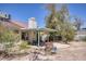 Backyard with covered patio, desert landscaping, and a spacious outdoor setting at 1590 Desertaire Way, Las Vegas, NV 89110