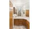 Bathroom featuring wood cabinets, tile countertops, vanity mirror and shower at 1590 Desertaire Way, Las Vegas, NV 89110