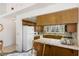 Well-lit kitchen with tile countertops and wooden cabinets offering plenty of storage space at 1590 Desertaire Way, Las Vegas, NV 89110
