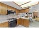 Bright kitchen with stainless steel oven and tile countertops, open to the adjacent living room with fireplace at 1590 Desertaire Way, Las Vegas, NV 89110