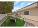 View of a cozy backyard with an outdoor seating area and green turf, perfect for relaxing and entertaining at 1619 Abby Ave, Henderson, NV 89014