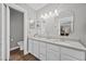Bright bathroom with double sink vanity, modern lighting, framed mirrors and wood-look flooring at 1619 Abby Ave, Henderson, NV 89014
