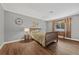 Comfortable bedroom with neutral decor, wood floors, large window, and a ceiling fan at 1619 Abby Ave, Henderson, NV 89014