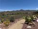 Landscaped backyard featuring desert plants, gravel pathways and views of mountains and the golf course at 18 Brookridge Dr, Henderson, NV 89052